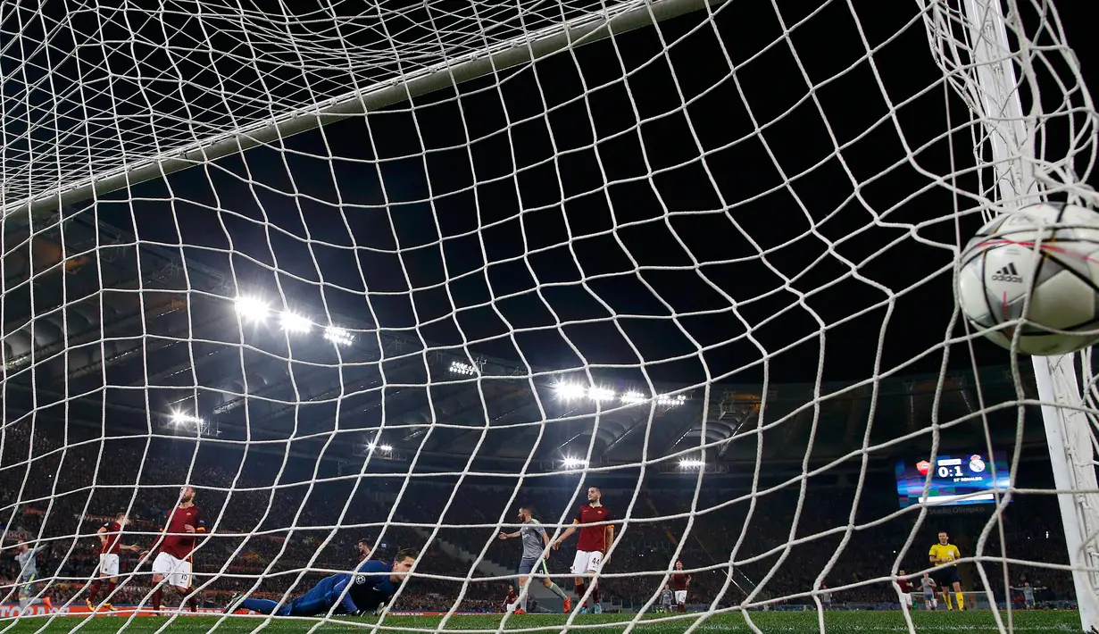 Kiper AS Roma, Wojciech Szczesny gagal menghalau bola tendangan Cristiano Ronaldo pada leg pertama 16 besar Liga Champions di Stadion Olimpico, Italia (18/2). Real Madrid menang atas AS Roma dengan skor 2-0. (REUTERS/Alessandro Bianchi)