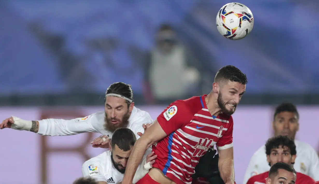 Bek Real Madrid, Sergio Ramos, duel udara dengan pemain Granada, Domingos Duarte, pada laga Liga Spanyol di Stadion Alfredo Di Stefano, Kamis (24/12/2020). Real Madrid menang dengan skor 2-0. (AP/Bernat Armangue)