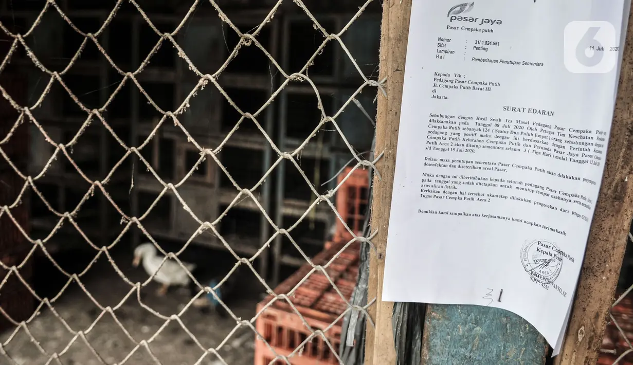 Selebaran informasi penutupan sementara terpasang di salah satu pintu masuk Pasar Cempaka Putih, Jakarta, Senin (13/7/2020). Pasar Cempaka Putih ditutup sementara lantaran sebanyak 41 pedagang dinyatakan positif COVID-19 berdasarkan swab test dengan metode PCR. (merdeka.com/Iqbal S. Nugroho)