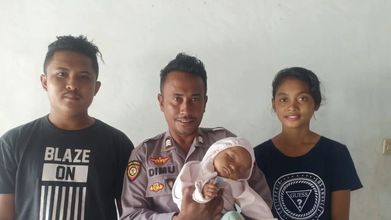 Polisi NTT, Brigpol Alfred Nikodemus Dimu berfoto bersama bayi yang dia selamatkan dan kedua orang tuanya. (Foto: Liputan6.com/Ola Keda)
