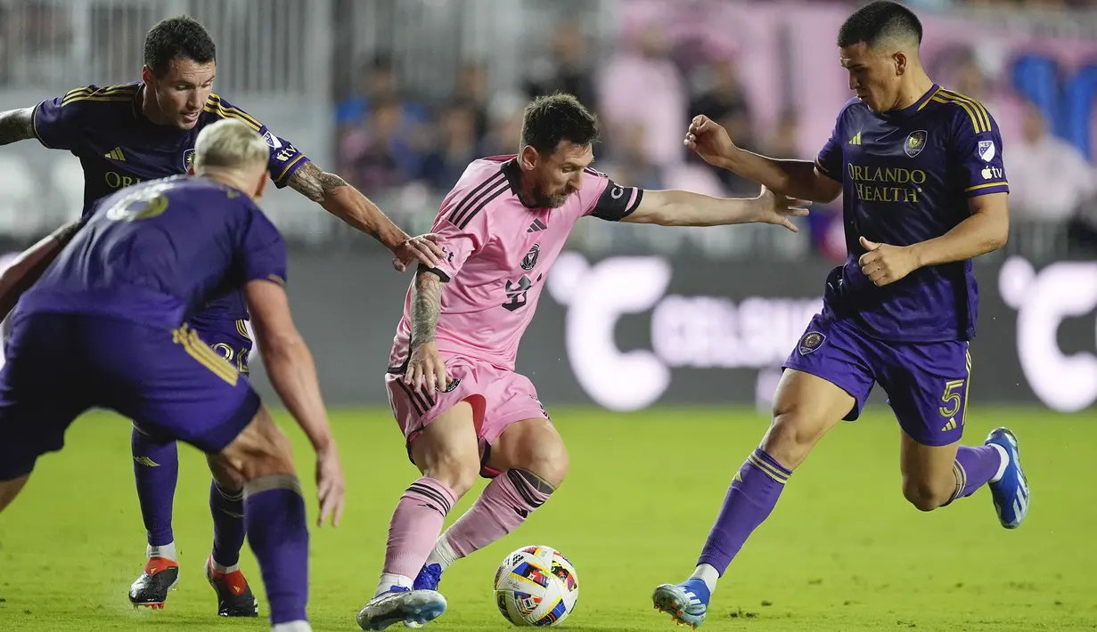 Pemain Inter Miami, Lionel Messi (tengah) berusaha melewati sejumlah penjagaan pemain Orlando City pada laga lanjutan Major League Soccer (MLS) 2024 yang berlangsung di Chase Stadium, Fort Lauderdale, Florida, Minggu (03/03/2024) WIB. The Herons menang dengan skor 5-0. (AP Photo/Rebecca Blackwell)