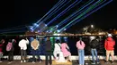 Sinar laser menerangi layar Sydney Opera House saat selama perayaan untuk menandai ulang tahunnya ke-50, Jumat (20/10/2023). (Saeed KHAN / AFP)