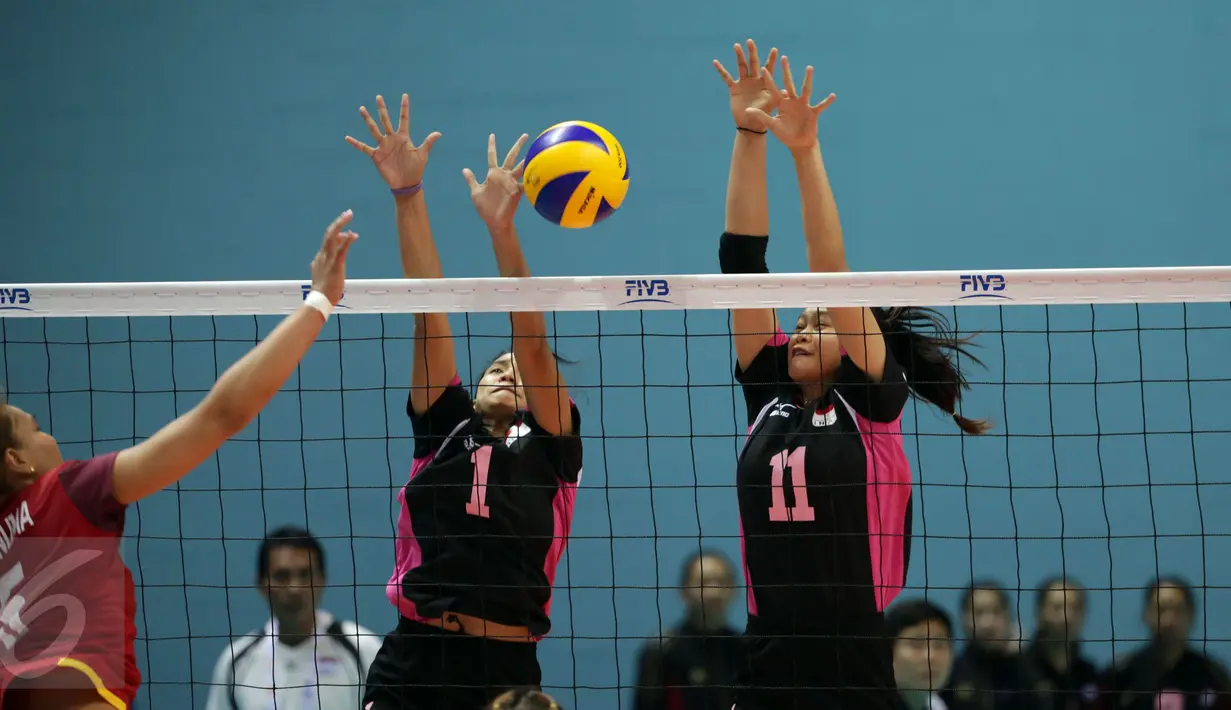 Dua pevoli putri Indonesia, Nadita AS (tengah) dan Wilda SN mencoba memblok smash pemain Thailand, Onuma S pada semifinal SEA Games ke-28 di OCBC Arena, Singapura, Minggu (14/6/2015). Indonesia kalah 1-3 dari Thailand. (Liputan6.com/Helmi Fithriansyah)