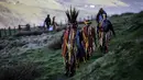 Anggota Powderkeg Morris Dancers meninggalkan Windgather Rocks usai melakukan festival Celtic kuno di High Peak di Derbyshire (1/5). Acara ini dirayakan pada May Day atau awal musim panas. (AFP Photo/Lindsey Parnaby)