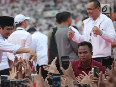 Ustaz Yusuf Mansur bersalaman dengan pendukung pasangan Capres dan Cawapres nomor urut 01, Jokowi - Ma'ruf Amin saat mengikuti kampanye akbar bertajuk 'Konser Putih Bersatu di Stadion Gelora Bung Karno (SGBK), Jakarta, Sabtu (13/4). (Kapanlagi.com/Budi Santoso)