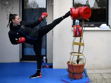 Alexandra Recchia berlatih di taman rumahnya di L'Hay-les-Roses, dekat Paris, Prancis, 3 April 2020. Juara dunia karate sebanyak lima kali ini tetap berlatih selama karantina wilayah atau lockdown untuk mencegah penyebaran virus corona COVID-19 di Prancis. (Photo by FRANCK FIFE/AFP)