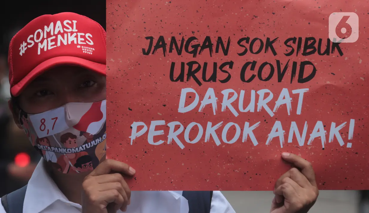 Seorang pria dari Massa Aliansi Kompak menujukkan poster tuntutan di depan Kemenkes, Jakarta, Kamis (26/11/2020). Revisi Peraturan Pemerintah No. 109 Tahun 2012 (PP 109/2012) terkait pengamanan bahan yang mengandung zat adiktif berupa produk tembakau bagi kesehatan. (Liputan6.com/Herman Zakharia)