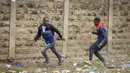Seorang pria tak dikenal memegang pisau mencoba merampok seorang pejalan kaki saat bentrokan antara polisi dan pengunjuk rasa di lingkungan Mathare di Nairobi, Kenya Rabu, 12 Juli 2023. (AP Photo)