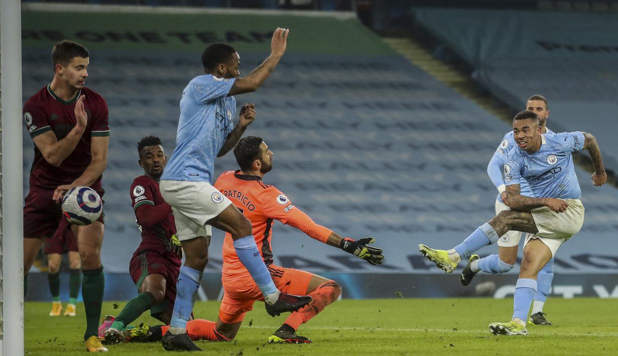 Striker Manchester City, Gabriel Jesus (kanan) melepaskan tendangan yang berbuah gol kedua timnya ke gawang Wolverhampton Wanderers dalam laga lanjutan Liga Inggris 2020/21 pekan ke-27 di Etihad Stadium, Selasa (2/3/2021). Manchester City menang 4-1 atas Wolverhampton. (AP/Carl Recine/Pool)