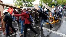 Dengan menggunakan ketapel, salah satu pengunjuk rasa menembaki polisi yang berjaga saat berlangsungnya peringatan Hari Buruh Sedunia di Istanbul, Turki (1/5/2014). (REUTERS/Umit Bektas)
