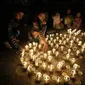 Orang-orang menggunakan lilin untuk membuat angka 60, yang mewakili menit dalam satu jam, saat memperingati Earth Hour di La Paz, Bolivia, Sabtu, 25 Maret 2023. Earth Hour berlangsung di seluruh dunia pada pukul 8:30 malam waktu setempat dan merupakan seruan global untuk mematikan lampu selama 60 menit, sebagai tindakan simbolis untuk meningkatkan kesadaran tentang perubahan iklim. (AP Photo/Juan Karita)