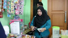 Nuraeni begitu bahagia. Ibu berusia 52 tahun itu dari hasil kerja kerasnya telah membuahkan hasil. Berawal dari jualan es teh manis yang dititipkan di kantin-kantin sekolah, ia sekarang bisa membuka warung sendiri. Sebelum usahanya berkembang seperti sekarang, Eni menceritakan awal merintis usahanya. Setelah usaha jualan es teh manis, ia memberanikan diri meminjam uang sebesar Rp 2 juta pada PNM Mekaar (Membina Ekonomi Keluarga Sejahtera). Produk Pembiayaan Kelompok Mekaar adalah layanan pemberdayaan berbasis kelompok bagi perempuan pra-sejahtera pelaku Usaha Ultra Mikro. Uang hasil pinjaman, Eni kemudian membelikannya sebuah kulkas freezer agar bisa menambah keuntungan dari jualan es teh manis. Makin hari usahanya terus berkembang. Hingga Eni terpikir berani membuka usaha warung sendiri. "Alhamdulillah. Selain es teh manis, saya juga ada minuman-minuman, mie. Sekarang saya sudah bisa buka warung di rumah," kata Eni saat berbincang di kediamannya Jakarta. (Foto: Dokumentasi BRI)