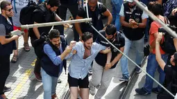 Seorang aktivis LGBT diamankan polisi berpakaian preman ketika mencoba melancarkan pawai tahunan LGBTI, di Istanbul, Minggu (26/6). Satu pekan sebelumnya, pemerintah Turki telah mengeluarkan larangan menggelar pawai tahunan LGBTI. (REUTERS/Osman Orsal)