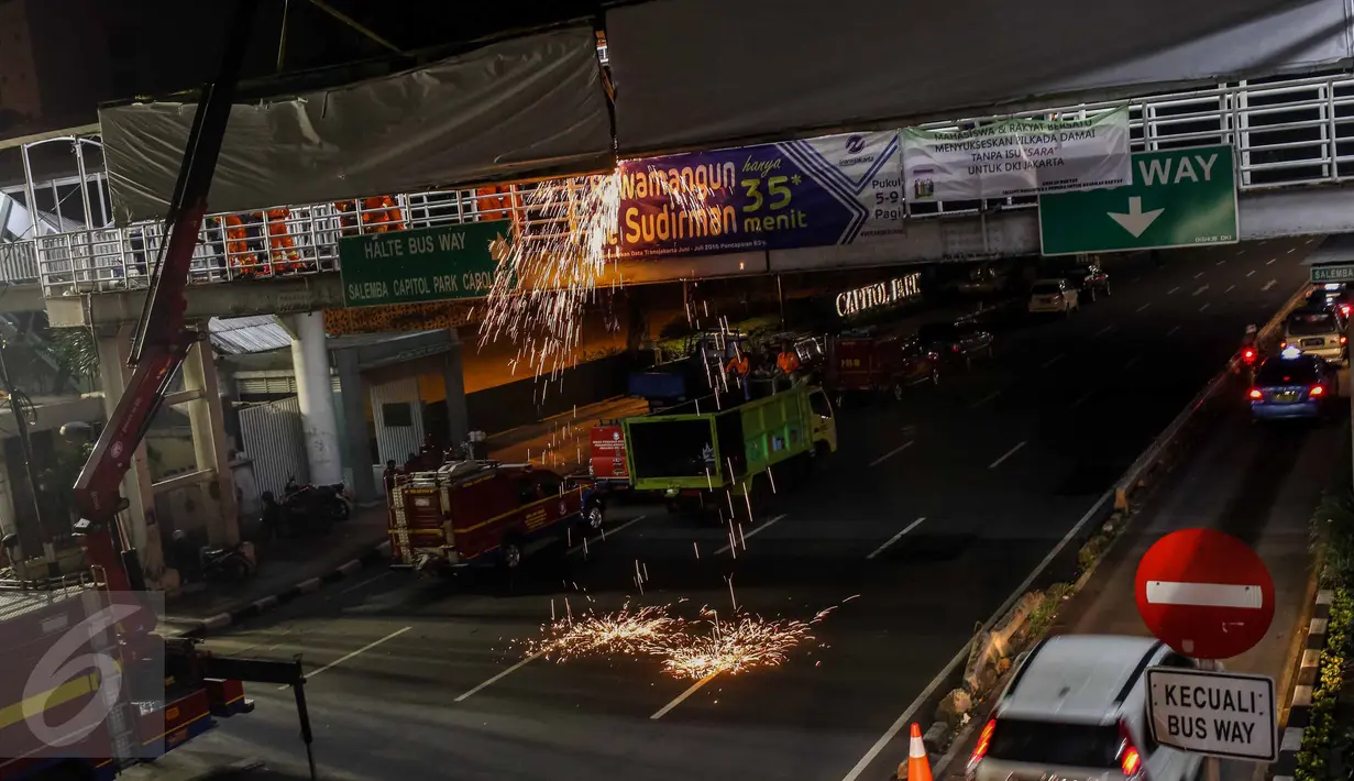 Kendaraan berat crane diterjunkan untuk membantu proses pembongkaran papan reklame yang terpasang di JPO kawasan Salemba, Jakarta, Rabu (26/10) malam. Pembongkaran dilakukan lantaran  papan reklame itu diketahui tidak berizin. (Liputan6.com/Faizal Fanani)