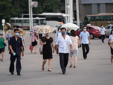 Pejalan kaki melewati alun-alun saat suhu tinggi mencapai 34 derajat celsius di Pyonyang, Korea Utara, Rabu (21/7/2021). Musim Panas dimulai pada bulan Juni hingga Agustus, dan puncak musim panas adalah bulan Agustus. (KIM Won Jin / AFP)