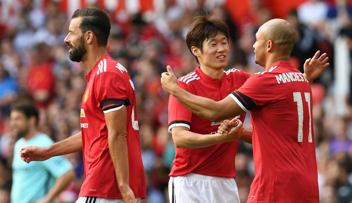 Legenda Manchester United, Ji-sung Park dan Danny Webber merayakan kemenangan saat bertanding melawan Legenda Barcelona di Stadion Old Trafford, Sabtu (2/9/2017). Pertandingan tersebut merupakan laga amal. (AFP/Paul Ellis)