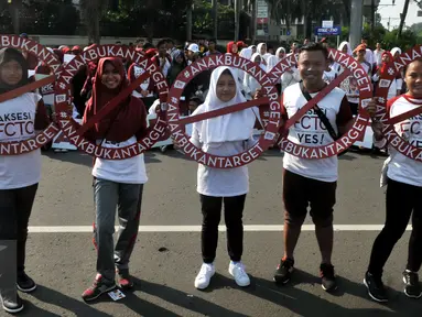 Massa yang tergabung dari Lentera Anak Indonesia menggelar aksi solidaritas di Bundaran HI Jakarta, Minggu (24/7). Memperingati Hari Anak, mereka meminta Presiden Jokowi melindungi anak-anak Indonesia dari dampak konsumsi rokok. (Liputan6.com/Johan Tallo)