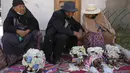 Orang-orang duduk dengan tengkorak manusia yang dihias untuk diberkati oleh seorang imam selama Festival Natitas di Pemakaman Umum di La Paz, Bolivia, Selasa (8/11/2022). Tradisi tahunan ini merayakan kematian di Bolivia dengan tengkorak yang dirawat dan didekorasi oleh mereka yang menggunakannya sebagai jimat untuk perlindungan. (AP Photo/Juan Karita)