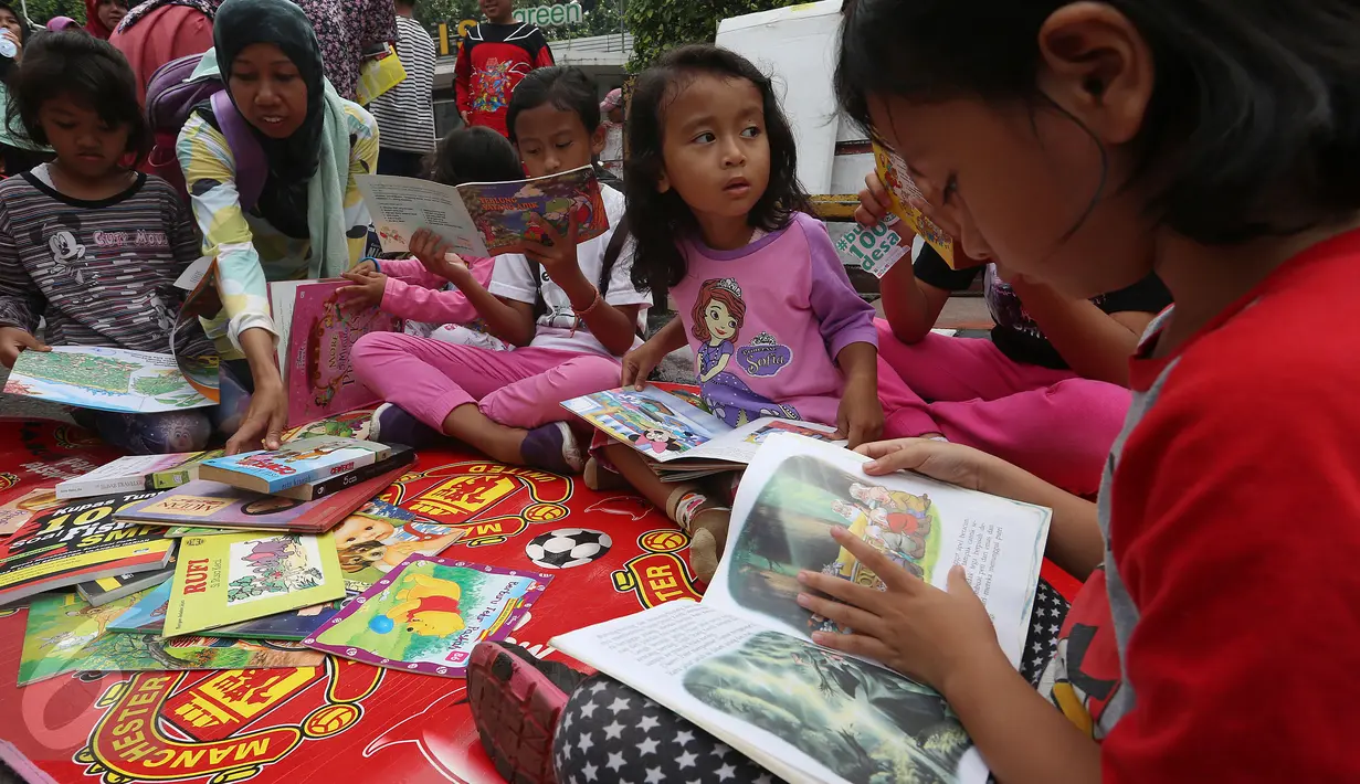 Sejumlah anak membaca buku di Kawasan Bundaran HI saat berlangsungnya Hari Bebas Kendaraan Bermotor atau Car Free Day (CFD), Jakarta, Minggu (2/4). Gerakan yang digagas oleh komunitas "Buku 100 Desa" . (Liputan6.com/Johan Tallo)
