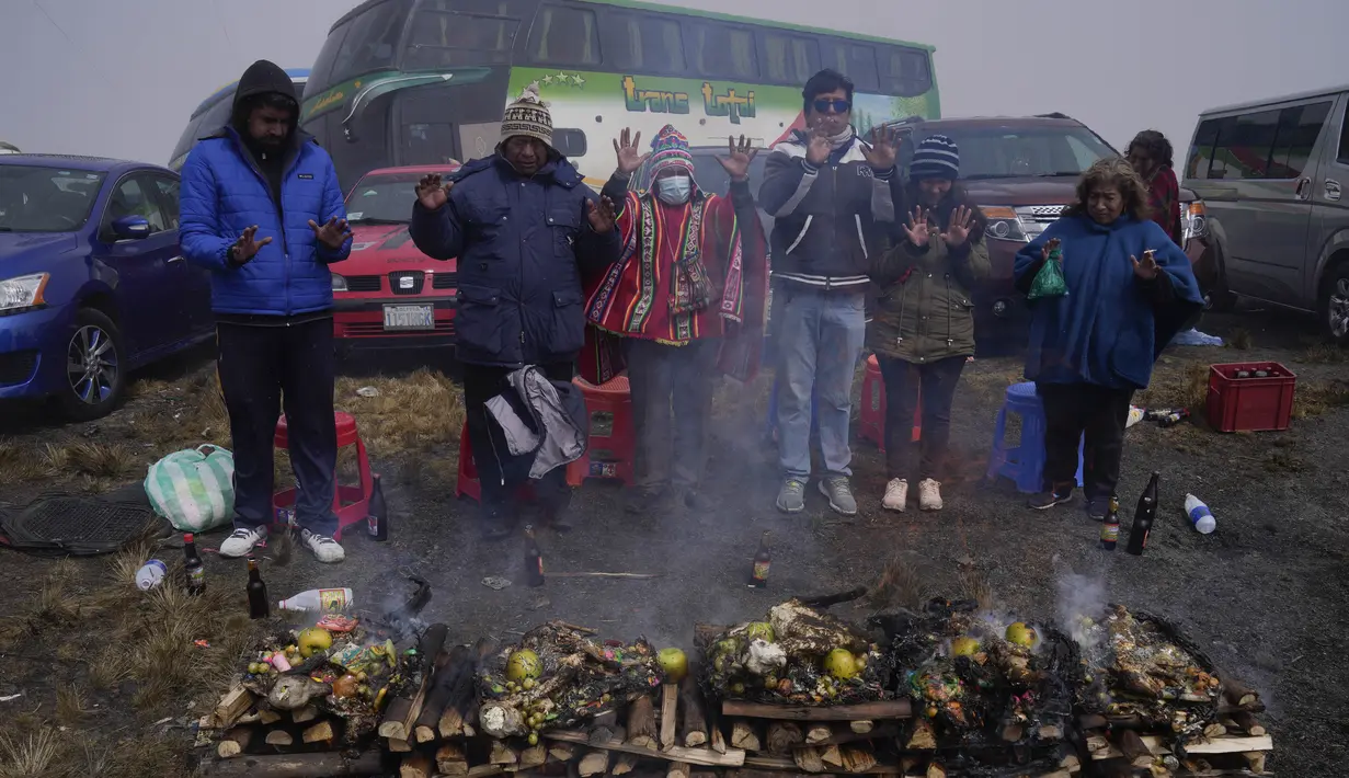 Orang-orang membakar persembahan untuk menghormati Pachamama atau Ibu Pertiwi di La Cumbre, sebuah gunung yang dianggap suci di pinggiran La Paz, Bolivia, Minggu (1/8/2021). Menurut tradisi Aymara, Pachamama terbangun lapar dan haus setiap bulan Agustus setelah musim kemarau. (AP Photo/Juan Karita)