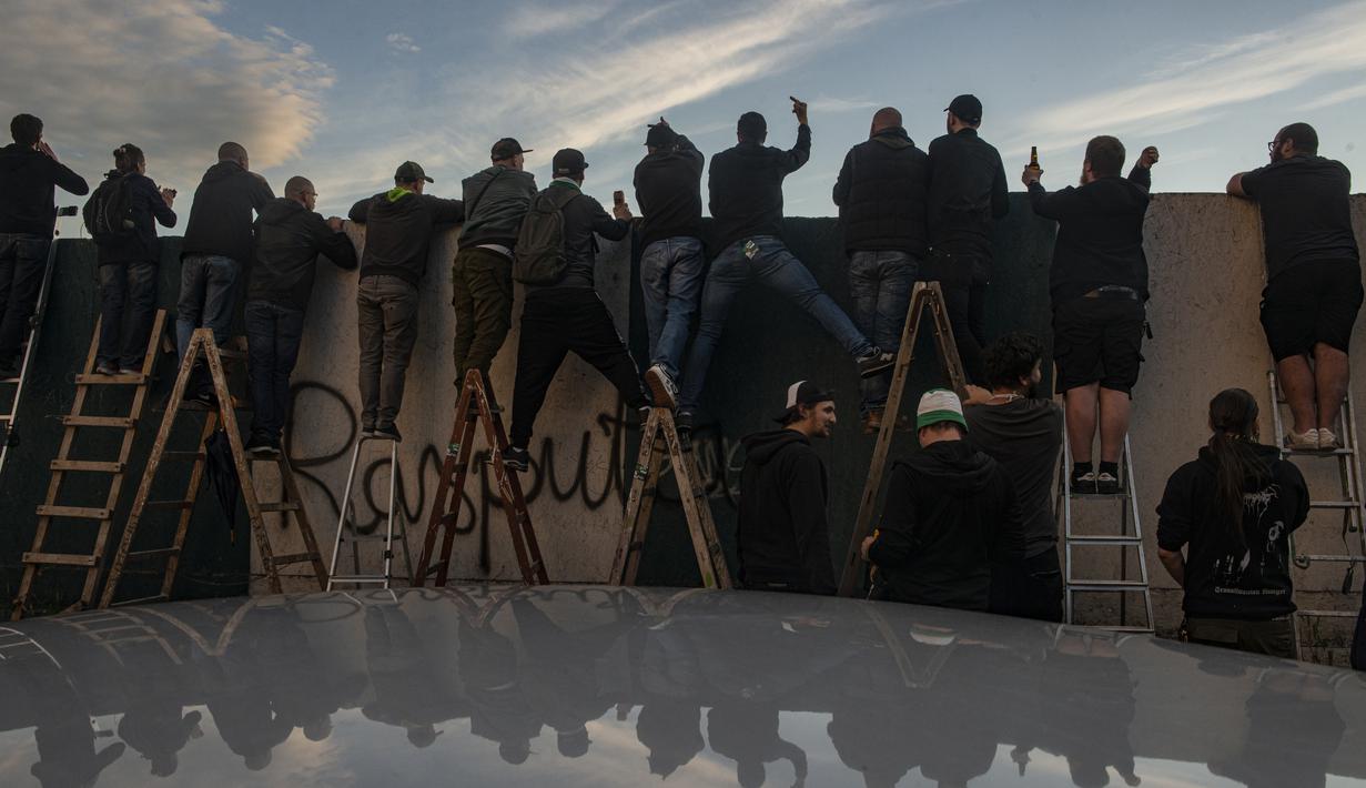 Suporter Bohemians 1905 menyaksikan pertandingan melawan Sparta Praha pada laga Liga Fortuna di Praha, Rep. Ceko (6/6/2020). Laga tertutup karena pembatasan virus corona tersebut membuat fans menonton dari balik tembok. (AFP/Michal Cizek)