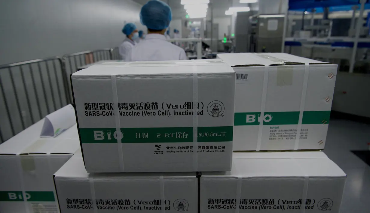 Kardus berisi kotak vaksin COVID-19 yang ditumpuk terlihat di bengkel pengemasan selama tur media di kantor pusat Sinopharm di Beijing pada 26 Februari 2021. The Beijing Institute of Biological Products mengembangkan vaksin corona dari virus yang sudah dilemahkan. (Noel Celis/AFP)