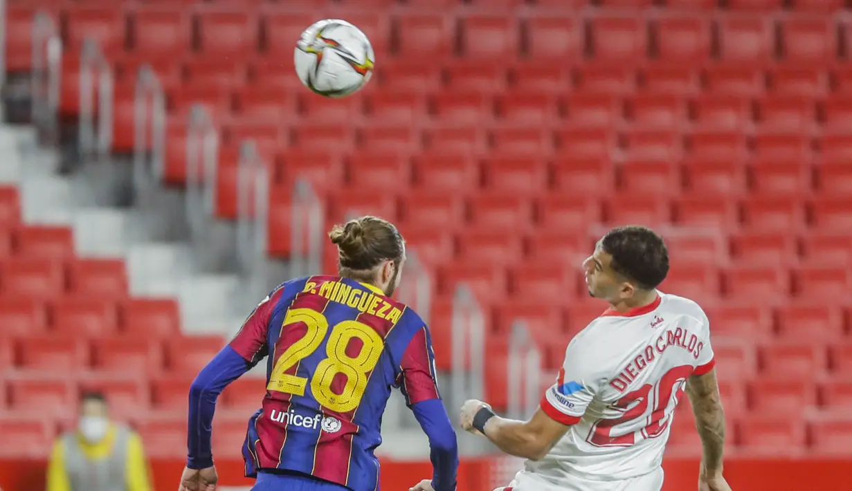 Bek Barcelona, Oscar Mingueza berebut bola udara dengan bek Sevilla, Diego Carlos pada pertandingan leg pertama semifinal Copa del Rey di stadion Ramon Sanchez Pizjuan di Seville, Spanyol, Kamis (10/2/2021).  Sevilla menang atas Barcelona 2-0. (AP Photo/Angel Fernandez)