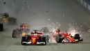 Pembalap Ferrari, Kimi Raikkonen dari Finlandia bertabrakan dengan rekan satu timnya Sebastian Vettel dari Jerman pada awal Grand Prix Singapura Formula One di Sirkuit Marina Bay City, Singapura, Minggu, (17/09) (AP Photo / Yong Teck Lim)