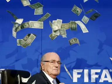 Presiden FIFA, Sepp Blatter terdiam saat uang kertas dilemparkan kepada dirinya saat tiba untuk konferensi pers usai Rapat Luar Biasa Komite Eksekutif FIFA di markas FIFA di Zurich, Swiss (20/7/2015). (REUTERS/Arnd Wiegmann)