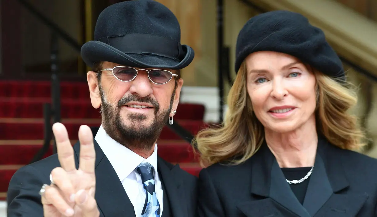 Ringo Starr berpose dengan istrinya Barbara Bach saat tiba untuk menerima gelar kebangsawanan dari kerajaan Inggris di Istana Buckingham, di London (20/3). Ringgo diberi gelar 'Sir' atas jasanya dalam dunia musik. (John Stillwell / Pool Photo via AP)