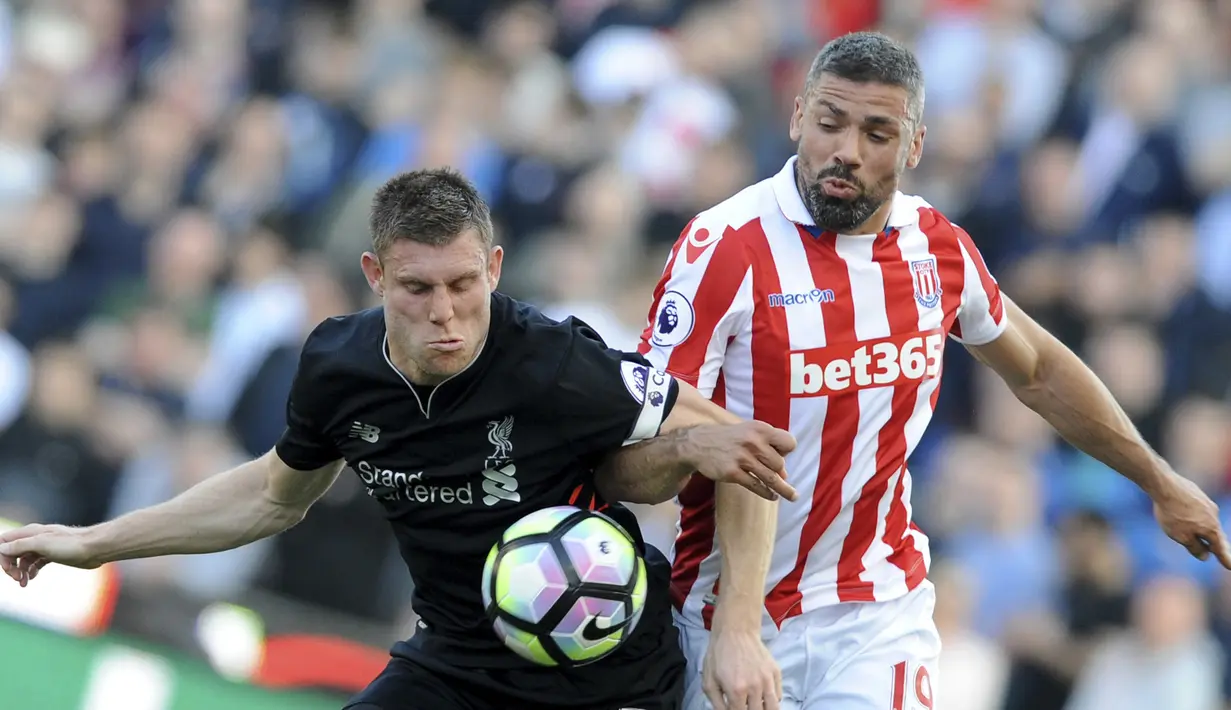 Ekspresi pemain Liverpool, James Milner (kiri) saat berebut bola dengan pemain Stoke City, Jonathan Walters pada laga Premier League pekan ke-32 di Britannia Stadium, Stoke, (8/4/2017). Liverpool menang 2-1. (AP/Rui Vieira)