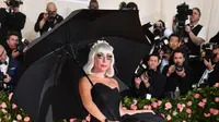 Lady Gaga mengenakan gaun dan payung hitam saat menghadiri Met Gala 2019 yang digelar di The Metropolitan Museum of Art, New York, Amerika Serikat, Sanin (6/5/2019). Lady Gaga tahun ini bertindak sebagai co-chair Met Gala. (Photo by Charles Sykes/Invision/AP)