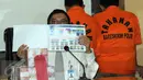 Petugas menunjukkan barang bukti saat rilis kasus peredaran uang palsu di Gedung Bareskrim, Jakarta, Senin (23/5). Polisi menangkap dua orang tersangka pemalsu uang Rupiah pecahan Rp 100.000 berinisial SW (58) dan MAR (59). (Liputan6.com/Helmi Afandi)