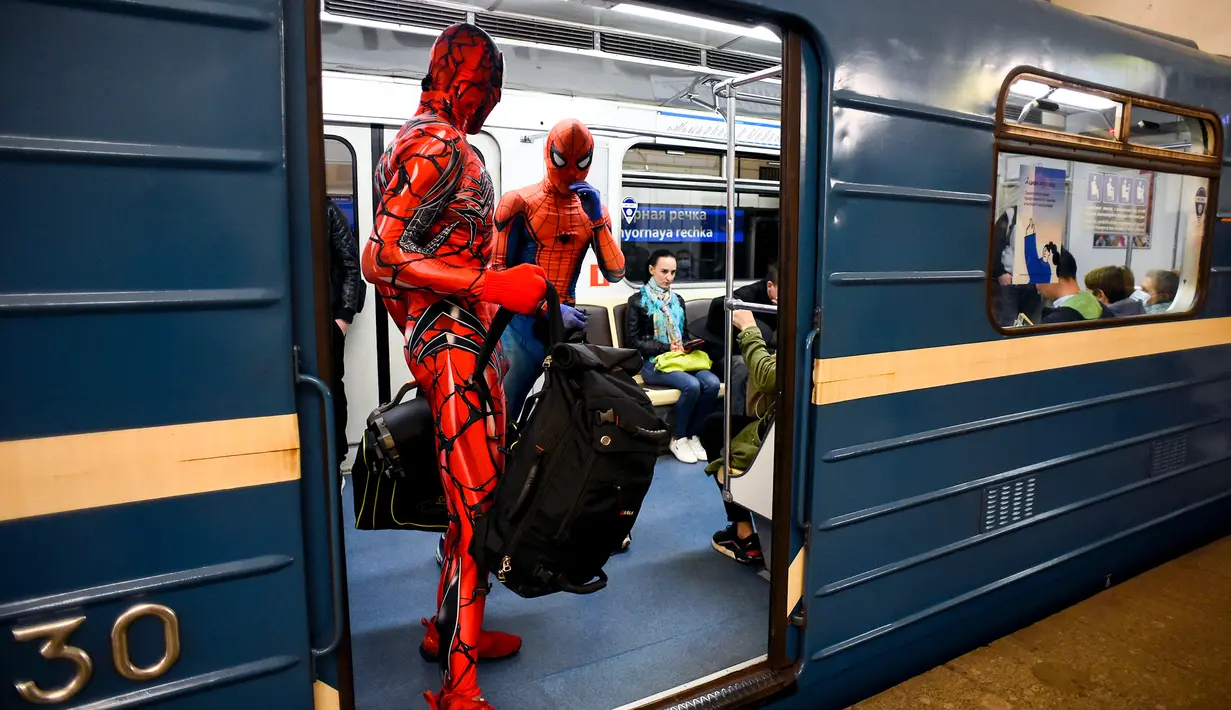 Penari underground yang mengenakan kostum Spiderman membawa tas mereka di kereta bawah tanah Saint Petersburg, pada 21 Mei 2021. Penamplan khusus penari Rusia tersebut membuat sejumlah penumpang yang berada di dalam subway kaget dan terhibur. (Olga MALTSEVA / AFP)