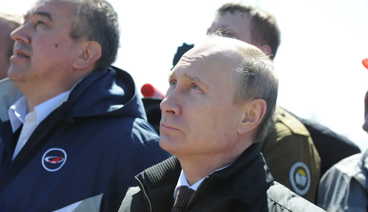 Presiden Rusia Vladimir Putin (depan) menyaksikan peluncuran roket Soyuz-2.1A dari kosmodrom Vostochny baru dalam misi membawa satelit Lomonosov, Aist-2D, dan Samsat-218 di Amur Region, Rusia, (28/4). (REUTERS/ Kirill Kudryavtsev)