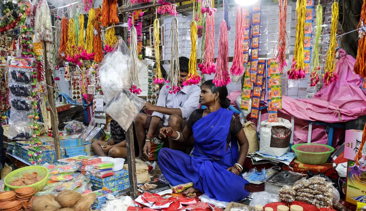 Pedagang menjual perlengkapan ibadah di kios pinggir jalan menjelang festival Hindu Chhath, di Kolkata, India (9/11/2021). Selama Chhath, festival Hindu kuno yang populer di kalangan kelas pekerja, ritual dilakukan untuk berterima kasih kepada Dewa Matahari. (AP Photo/Bikas Das)