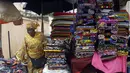 Seorang perempuan menjual kain di pasar Kaporo di Conakry, Guinea, Senin (13/9/2021). Pasukan elit militer Guinea melakukan kudeta dan menangkap Presiden Alpha Conde pada Minggu, 5 September lalu. (AP Photo/ Sunday Alamba)