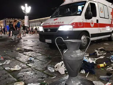 Mobil ambulans berusaha mengevakuasi korban usai terjadi ledakan saat nonton bareng final Liga Champions di Piazza San Carlo, Turin, Sabtu (3/6/2017). Acara nobar dipadati sekitar 20.000 supporter Juventus. (AP/Alessandro Di Marco)