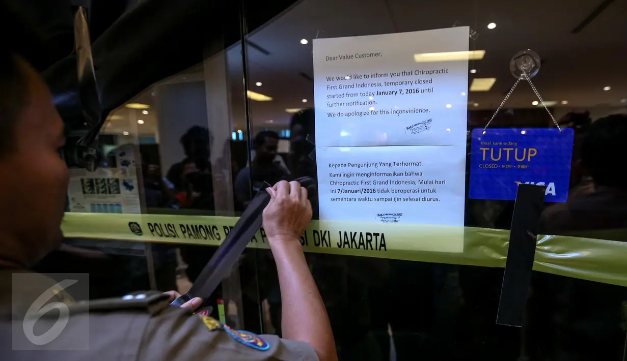 Anggota Satpol PP ketika menyegel klinik Chiropractic First di pusat perbelanjaan Grand Indonesia, Jakarta, Rabu (13/1). Sebanyak sembilan klinik Chiropractic First di sejumlah mall di Jakarta disegel serentak. (Liputan6.com/Faizal Fanani)