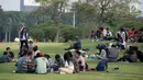 Warga duduk di rumput ketika mengunjungi kawasan Monumen Nasional (Monas) ) saat hari libur Lebaran hari kedua, Jakarta, Kamis (6/6/2019). Monas yang merupakan Ikon Ibu Kota itu menjadi salah satu tujuan wisata untuk mengisi libur Lebaran. (merdeka.com/Imam Buhori)