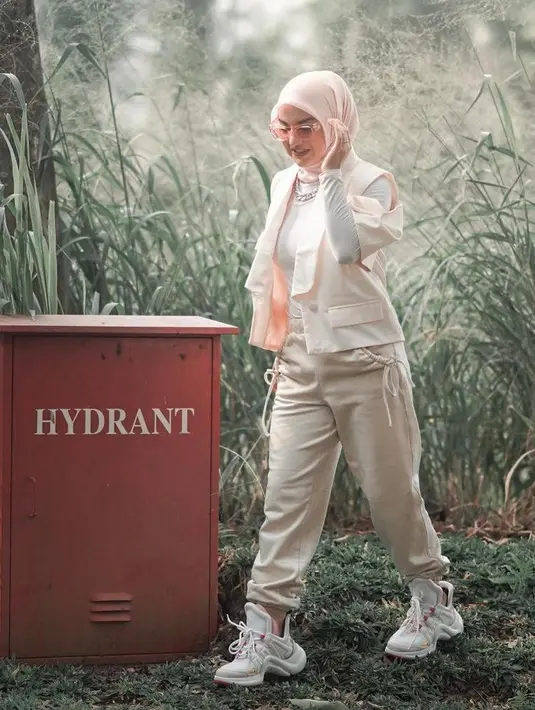 Aktris Irish Bella terlihat stylish kenakan long sleeve t-shirt warna putih, dipadukan dengan vest warna peach, dan celana jogger warna krem. (Instagram/_irishbella_).