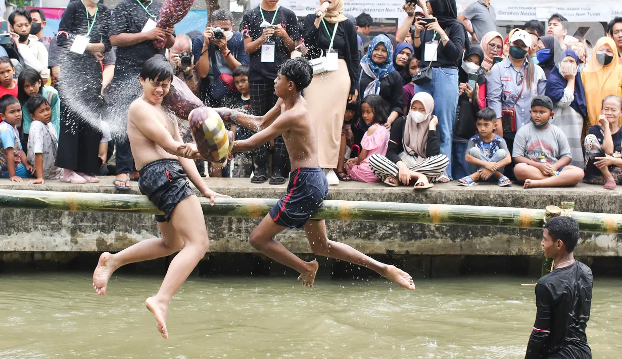 Dua orang anak mengikuti perlombaan pukul bantal di aliran Kalimalang, Jakarta Timur, Sabtu (27/8/2022). Perlombaan di Kalimalang yang diselenggarakan kembali setelah dua tahun berhenti akibat pandemi covid-19 ini untuk memeriahkan peringatan HUT ke-77 Kemerdekaan RI. (Liputan6.com/Herman Zakharia)