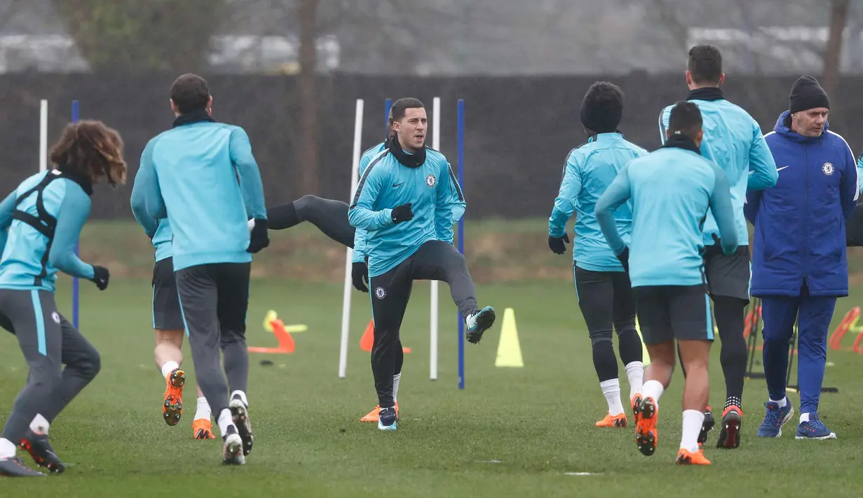Gelandang Chelsea Eden Hazard (tengah) melakukan pemanasan saat latihan jelang mengahadapi Barcelona pada babak 16 besar Liga Champions di fasilitas latihan Chelsea Cobham di Stoke D'Abernon, sebelah barat daya London (19/2). (AFP Photo/Adrian Dennis)