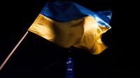 Bendera Ukraina terlihat saat Centre Block of Parliament Hill diterangi dengan warna biru dan kuning Ukraina saat peringatan satu tahun sejak invasi Rusia ke Ukraina di Parliament Hill, Ottawa, Ontario, Kanada, 24 Februari 2023. (Spencer Colby/The Canadian Press via AP)