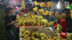 Pedagang menjual pisang dan kacang di pasar malam pada tradisi Malam Qunut di Desa Payunga, Kec. Batudaa, Kab. Gorontalo, Senin (20/5/2019). Tradisi Malam Qunut di Gorontalo dilakukan pada setiap pertengahan bulan Ramadan dengan beramai-ramai memakan pisang dan kacang. (Liputan6.com/Arfandi Ibrahim)