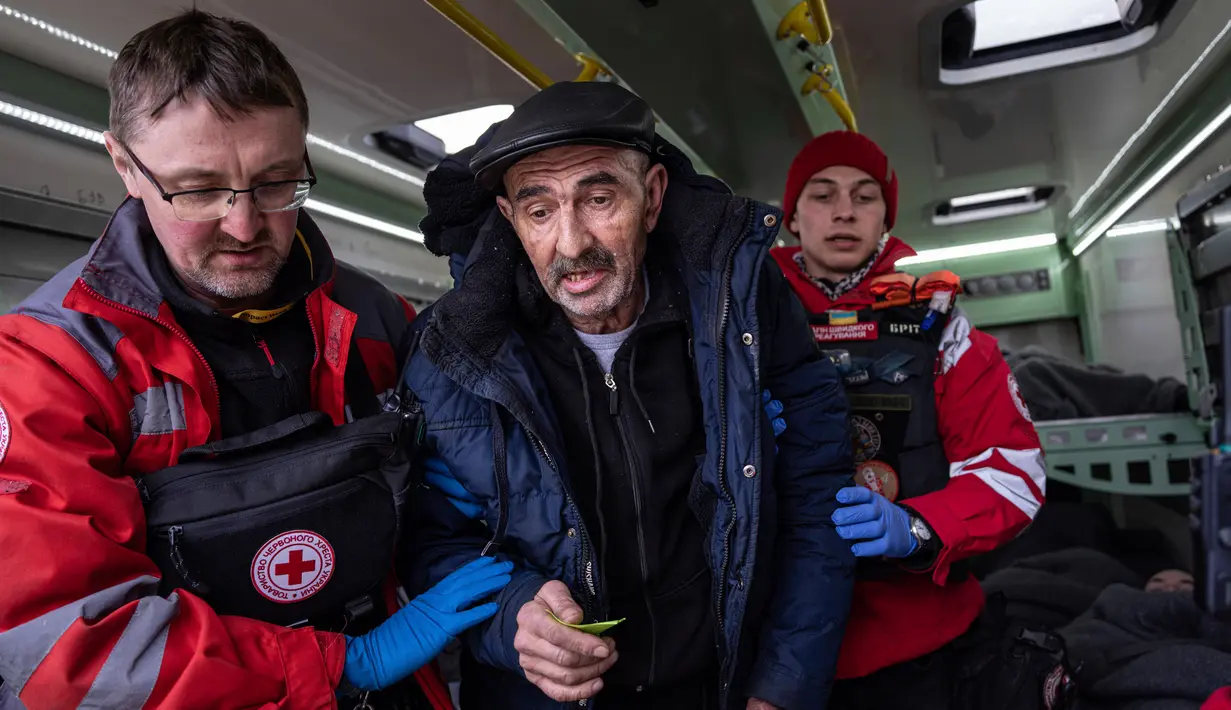 Relawan Palang Merah membantu seorang pria masuk ke dalam kereta medis Medecins Sans Frontieres (MSF) atau Doctors Without Border saat mengevakuasi pasien dari dekat garis depan pertempuran ke daerah yang lebih aman di stasiun kereta di Pokrovsk, Ukraina, 7 Maret 2023. MSF merupakan kereta medis khusus yang dapat membawa pasien dari bagian timur Ukraina ke rumah sakit di bagian barat. (AP Photo/Evgeniy Maloletka)