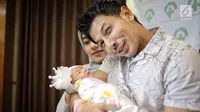 Senyum pasangan Fairuz A Rafiq dan Sonny Septian saat menunjukkan bayi perempuan mereka di Jakarta, Selasa (22/5). Fairuz melahirkan melalui operasi caesar. (Liputan6.com/Faizal Fanani)