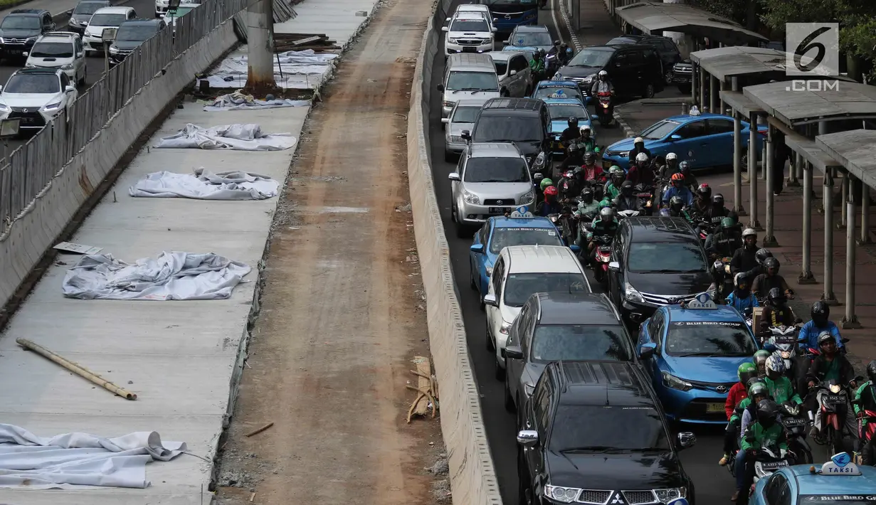 Sejumlah kendaraan terjebak macet di samping penataan jalan dan trotoar di Jalan Sudirman, Jakarta, Selasa (17/4). Trotoar tersebut akan dilebarkan menjadi 9 hingga 12 meter. (Liputan6.com/Arya Manggala)