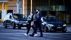 Orang-orang membawa monitor komputer untuk bekerja dari rumah di Canberra, Australia, Kamis (12/8/2021). Canberra melakukan lockdown selama tujuh hari setelah satu kasus COVID-19 terdeteksi. (Rohan Thomson/AFP)
