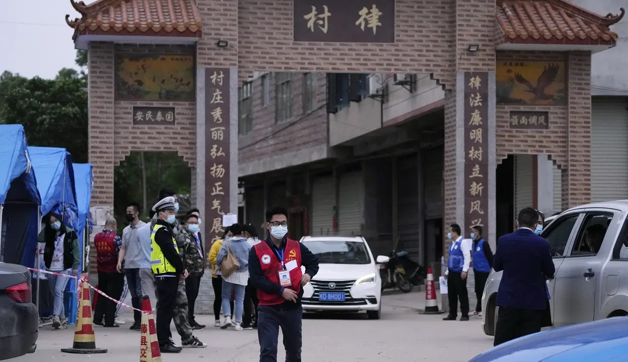 Petugas pemerintah mengontrol akses di pintu masuk desa Lu mengarah ke lokasi jatuhnya pesawat China Eastern di Guangxi, China barat daya, Selasa (23/3/2022). Insiden jatuhnya pesawat jenis Boeing 737-800 ini disebut bencana udara terburuk di China dalam hampir satu dekade. (AP Photo/Ng Han Guan)